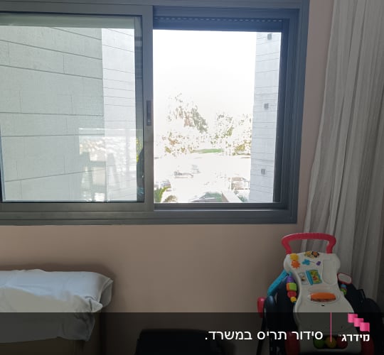 חלון עם תריסים פתוחים וחפצים בחדר